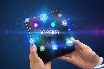 Businessman holding a foldable smartphone with YOUR STORY inscription, social media concept
