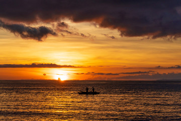 Fototapeta premium Fishermen catch fish at a beautiful sunset