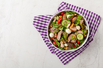Salad with pork tenderloin, fresh cucumber and mozzarella.