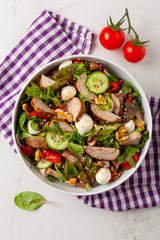 Salad with pork tenderloin, fresh cucumber and mozzarella.