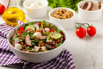 Salad with pork tenderloin, fresh cucumber and mozzarella.