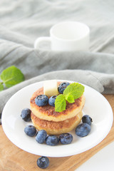A healthy breakfast of pancakes, berries, butter, and honey