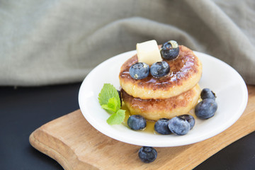 A healthy breakfast of pancakes, berries, butter, and honey