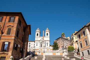 Fototapeta na wymiar Trinità dei Monti Church on top of Spanish Steps in Rome Italy. With 138 steps in total the Spanish Steps of Rome are the longest and widest outdoor steps in Europe.