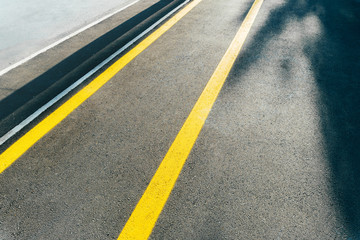 Photo of yellow bike lines on asphalt in the city, bike traffic street.