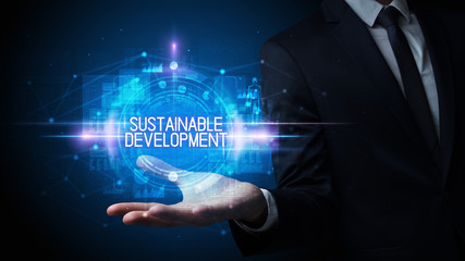 Man hand holding SUSTAINABLE DEVELOPMENT inscription, technology concept