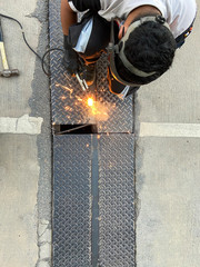 staff welder is doing maintenance on the damaged cutter rails on the road.