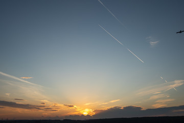 Plane over the horizon. Sunset sky. 