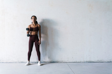 Fototapeta premium Photo of young african american sportswoman working out with dumbbell
