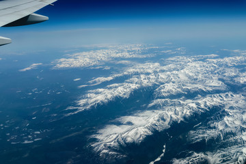 View from airplane on Earth surface - snow-capped mountains.