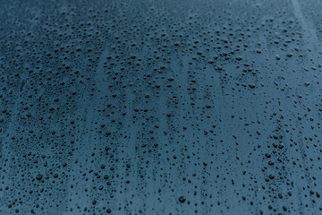 Texture of raindrops on the blue glass.