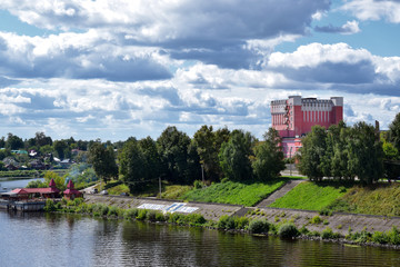 Obraz premium Kimry, Tver Region, Russia - August 19, 2020: View of the left bank of small town Kimry from the bridge. The building of the theater and the embankment on a sunny day