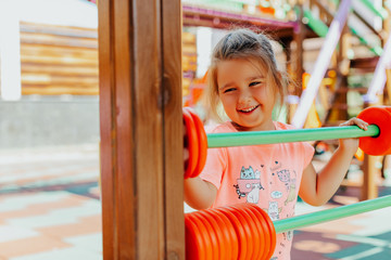 little girl playing on playground. cute smiling child playing in the new playground and counting 