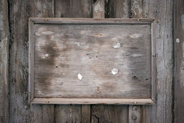 Aged wooden billboard frame with copy space on wooden wall background. Advertisement.