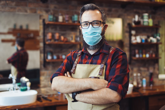 Portrait Of Barber At Barber Shop Wearing Protective Face Mask. Barber At The Time Of The Pandemic.