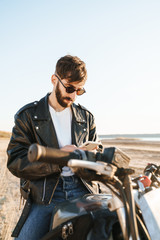 Handsome young bearded man wearing leather jacket