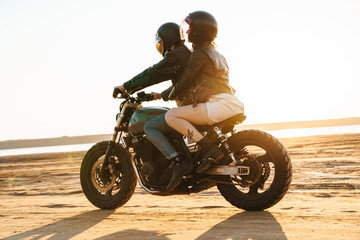 Obraz na płótnie Canvas Beautiful young stylish couple enjoying ride on a motorbike