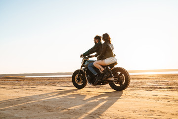 Fototapeta na wymiar Beautiful young stylish couple enjoying ride on a motorbike
