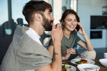 Lovely young couple having healthy breakfast in the kitchen