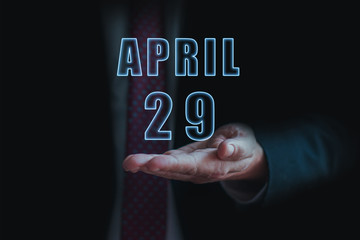 april 29th. Day 29 of month, announcement of date of  business meeting or event. businessman holds the name of the month and day on his hand.. spring month, day of the year concept