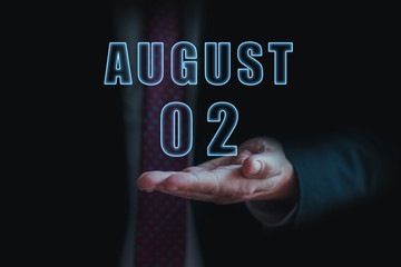 august 2nd. Day 2 of month, announcement of date of  business meeting or event. businessman holds the name of the month and day on his hand.. summer month, day of the year concept