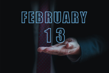 february 13th. Day 13 of month, announcement of date of  business meeting or event. businessman holds the name of the month and day on his hand.. winter month, day of the year concept