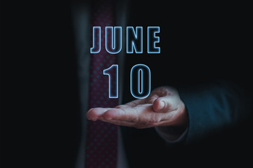 june 10th. Day 10 of month, announcement of date of  business meeting or event. businessman holds the name of the month and day on his hand.. summer month, day of the year concept