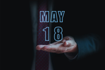 may 18th. Day 18 of month, announcement of date of  business meeting or event. businessman holds the name of the month and day on his hand.. spring month, day of the year concept