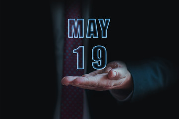 may 19th. Day 19 of month, announcement of date of  business meeting or event. businessman holds the name of the month and day on his hand.. spring month, day of the year concept