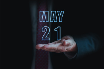 may 21st. Day 20 of month, announcement of date of  business meeting or event. businessman holds the name of the month and day on his hand.. spring month, day of the year concept