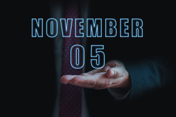 november 5th. Day 5 of month, announcement of date of business meeting or event. businessman holds the name of the month and day on his hand. autumn month, day of the year concept