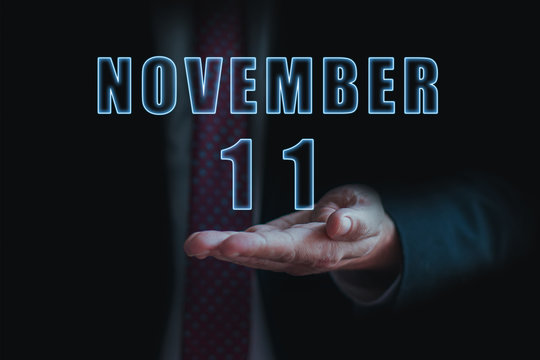 november 11th. Day 11 of month, announcement of date of business meeting or event. businessman holds the name of the month and day on his hand. autumn month, day of the year concept