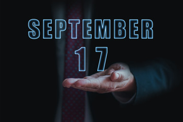 september 17th. Day 17 of month, announcement of date of business meeting or event. businessman holds the name of the month and day on his hand. autumn month, day of the year concept