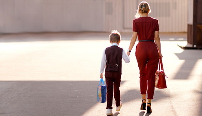 Mother with son on the way to new study year with bags