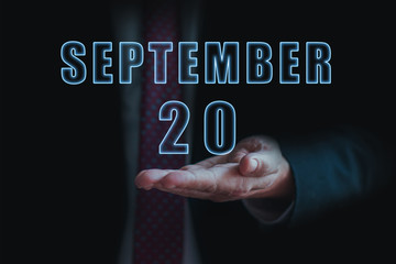 september 20th. Day 20 of month, announcement of date of business meeting or event. businessman holds the name of the month and day on his hand. autumn month, day of the year concept