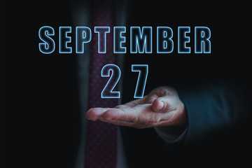 september 27th. Day 27 of month, announcement of date of business meeting or event. businessman holds the name of the month and day on his hand. autumn month, day of the year concept