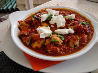 Mussels Saganaki with feta cheese on white plate