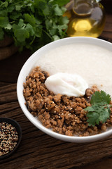 space congee with pork and egg on wood food background 