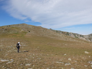 Jeune femme qui randonne en montagne hors sentier vers le massif du Madres dans les Pyrénées orientales en Occitanie