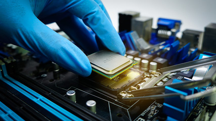 A computer technician attaches the CPU to the motherboard using gloves. Close up.