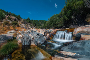 Fototapeta na wymiar La Pedriza National Park on the southern slopes of the Guadarrama mountain range in Madrid, with cascades. It is one of the largest granitic ranges. It has amazing nature and plenty of leisure options