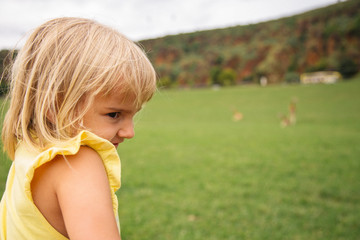 Little girl in profile at a green park