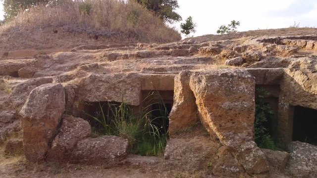 Archeological site, ancient old etruscan necropolis site. Tracking shot of catacombs, sunset, daytime time. Exterior, history concept. Aerial view. Cerveteri, Italy 