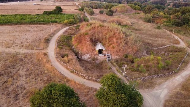 Orbiting a huge ancient tomb, tumulus. Archeological and necropolis catacombs site. Etruscan plane. Cerveteri, Italy 