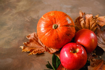 Seasonal fruits and vegetable. Autumn harvest. Pumpkin, apples and autumn maple leaves.