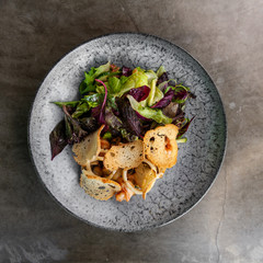 Caesar salad with shrimps in black plate