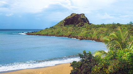 Tropical paradise with tall mountain, sea and white sand beach. Nature scene