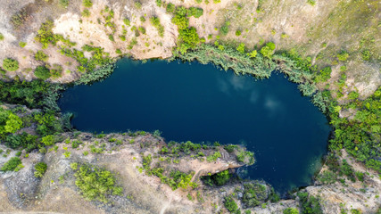 bird's eye view of a beautiful small lake with stone shores