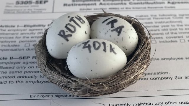 Conceptual composition. Pension savings. Individual retirement account. Three eggs with the inscriptions IRA, 401k, Roth lie in the nest against the background of the 5305-SEP form. Close-up