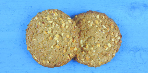 baked oatmeal cookies sprinkled with nuts on a wooden surface
